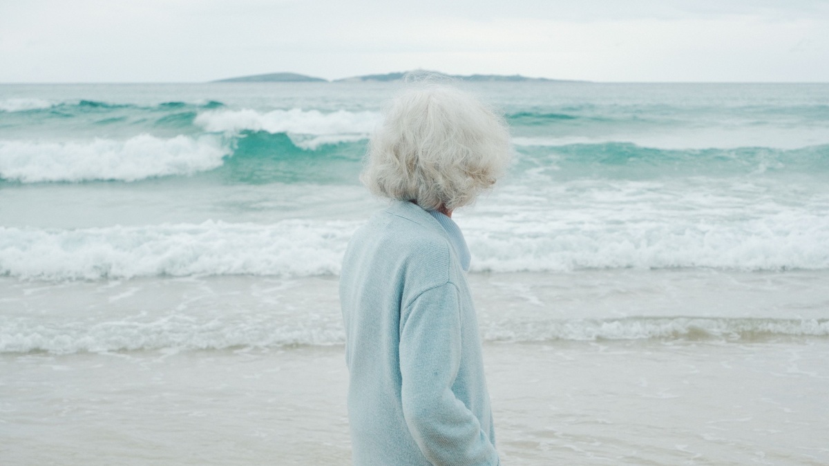 Older woman standing beside the ocean at Narooma on the New South Wales coast.